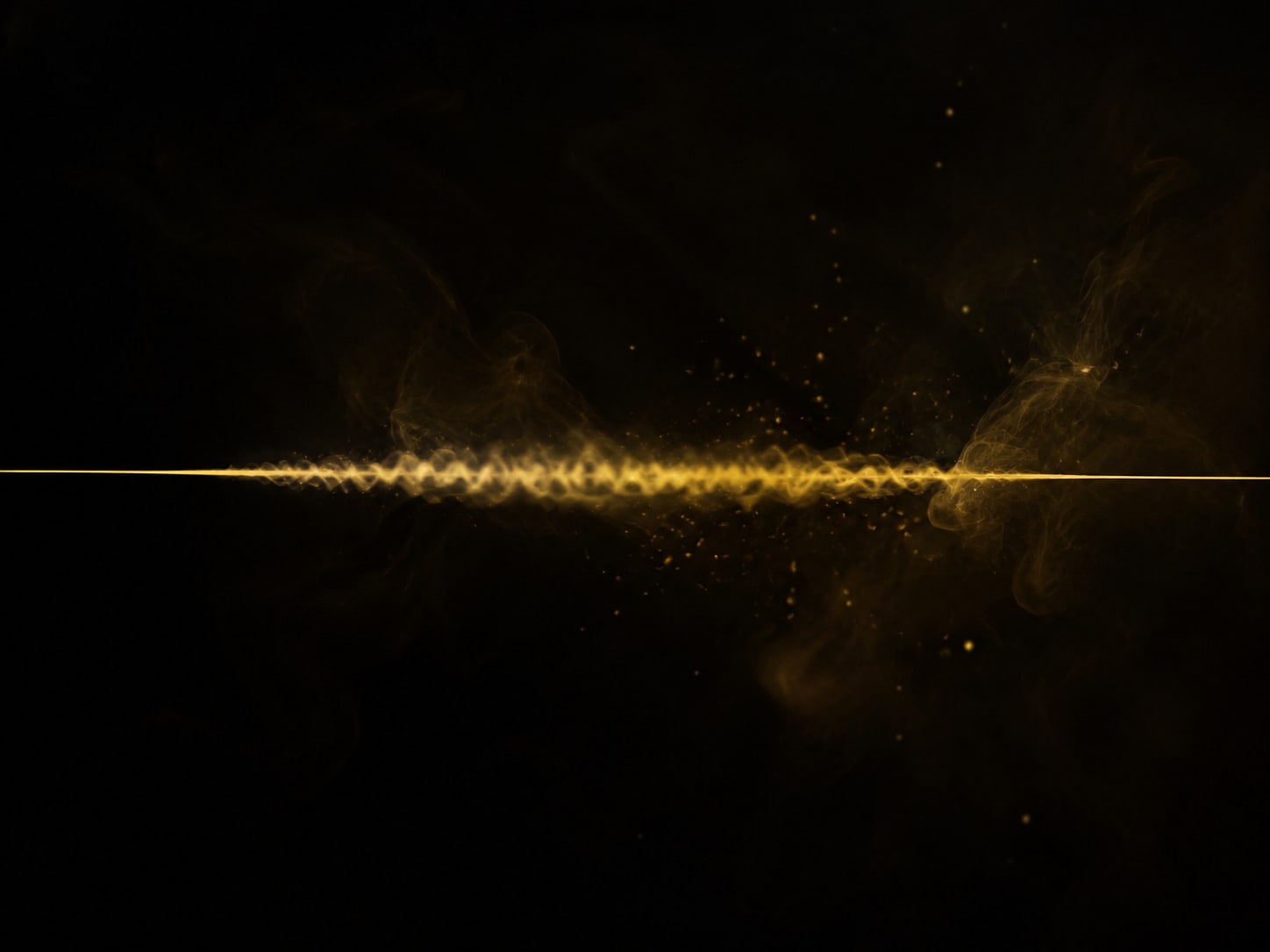 A fine gold filament stretched across darkness, blurred through its midsection where it vibrates.